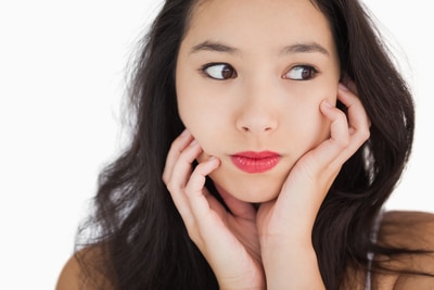 Woman looking afraid against white background