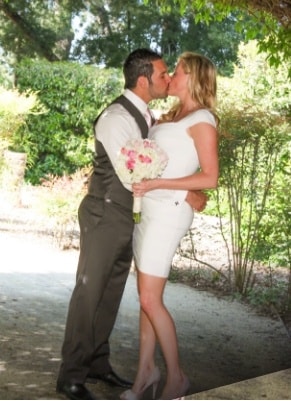 newly-wed couple kissing under the shade of a tree