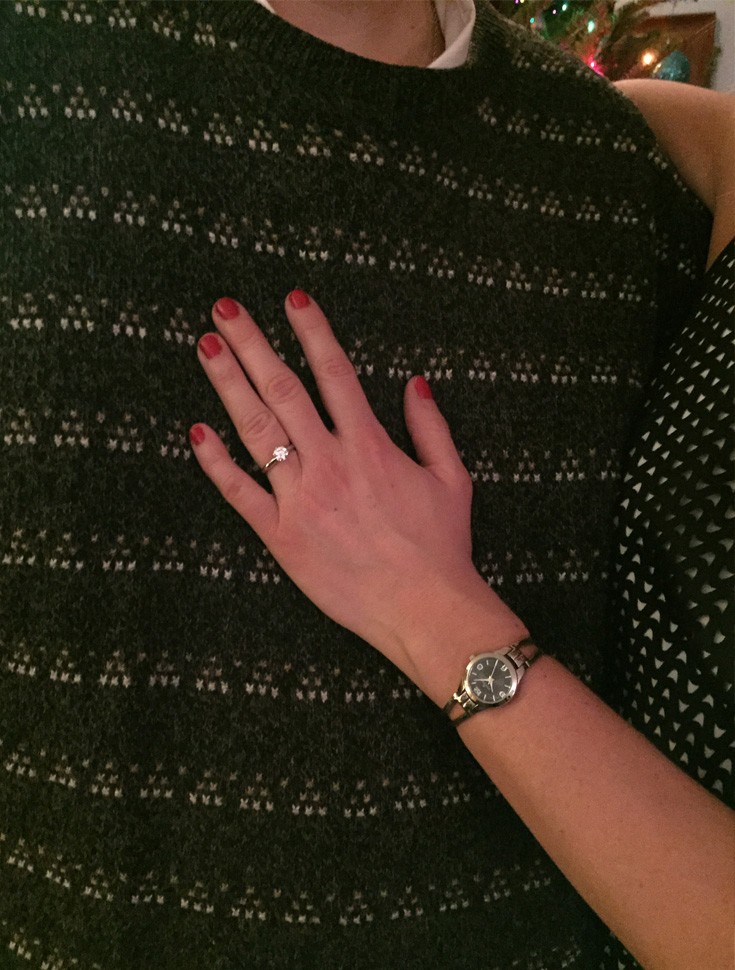 a woman's hand with an engagement ring on her finger