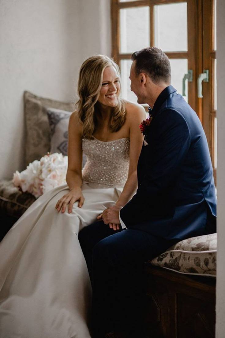 couple on their wedding attire, sitting on the couch