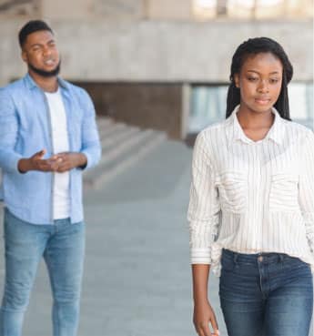 woman sadly walking away from her man