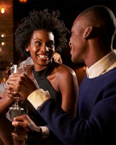 man and woman flirting on a bar while having drinks