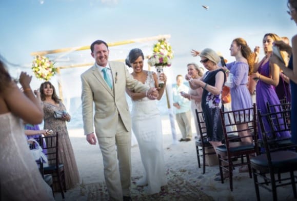 Love U love story of happy couple walking down the aisle with wedding guests applauding