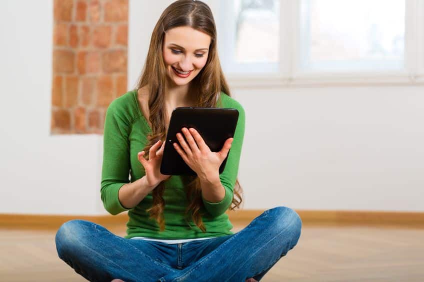 woman sitting on the floor with ipad on her hands