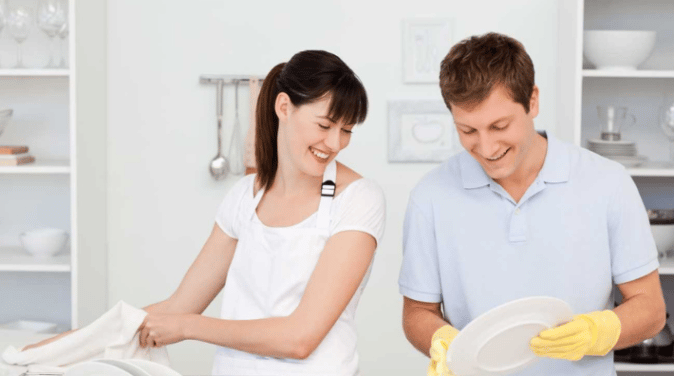 Lovers washing dishes together in their kitchen